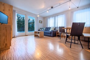 En moderne stue med sofa, sofabord og spiseplads.