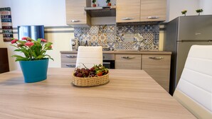 A modern kitchen with light wood cabinets, a tiled backsplash, and a stainless steel refrigerator. - Housestation (Palermo)