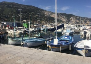A marina with boats docked, a clear sky, and a mountainous backdrop. - Bel Appartement Moderne : vue Mer, Menton Garavan (Menton)