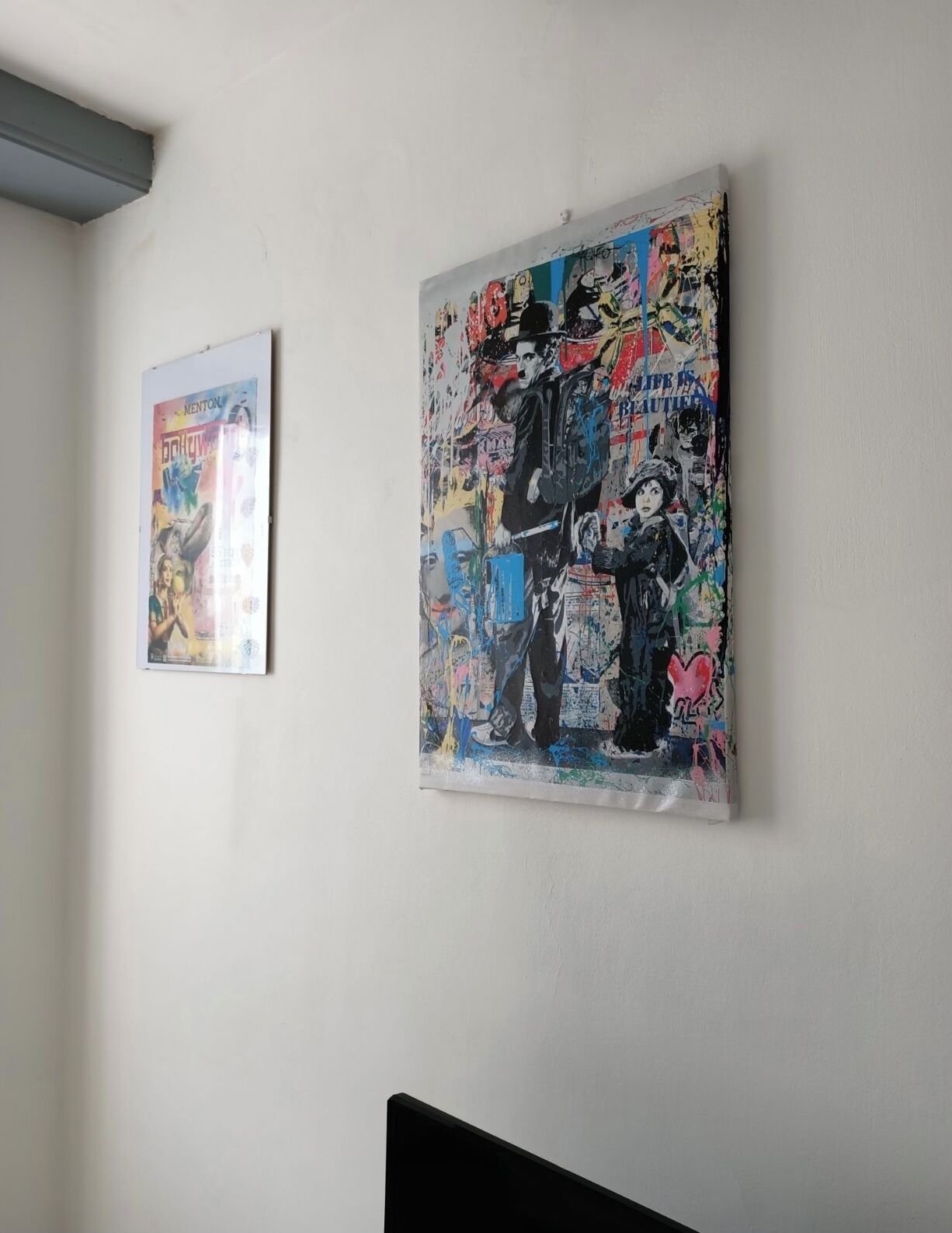 Two framed artworks on a plain wall.