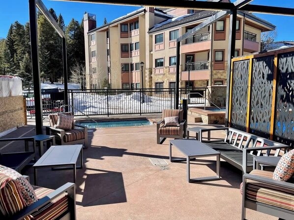 Une terrasse sur le toit avec des sièges extérieurs, une piscine et un bâtiment en arrière-plan.