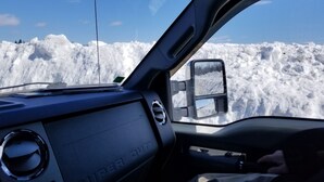 A vehicle's dashboard with a snow-covered landscape visible through the windshield.