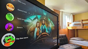 A television displaying a movie with a spaceship interior, a bunk bed, and a small seating area. - Key Lime Resorts - Unit #3 Key Lime Cottage (Monticello)