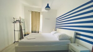 Una camera da letto con un letto, un comodino, un armadio e una lampada a sospensione.