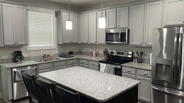 A modern kitchen with white cabinets, granite countertops, stainless steel appliances, and pendant lighting. - Pinehurst Golf Retreat, Pool Table, Fire Pit! (Pinehurst)