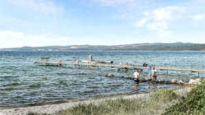 Une jetée s’avançant dans un lac, où des personnes se promènent et se tiennent debout.