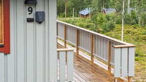 Une terrasse en bois mène à un bâtiment portant le numéro « 9 ».
