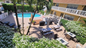 A rooftop pool area with lounge chairs, a pool, and a view of the surrounding buildings. - Pompano Holiday Gem (Pompano Beach)
