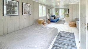 Ein geräumiges Zimmer mit einem großen Bett, einem blauen Sofa und einer Essecke.
