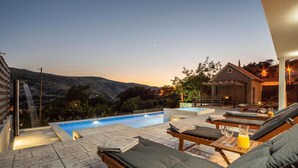 A rooftop pool area with lounge chairs and a small table with drinks, overlooking a mountainous landscape. - Gorgeous home in Srinjine (Srinjine)