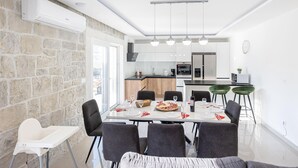 A modern kitchen with white cabinets, a built-in oven, and a refrigerator. - Gorgeous home in Srinjine (Srinjine)