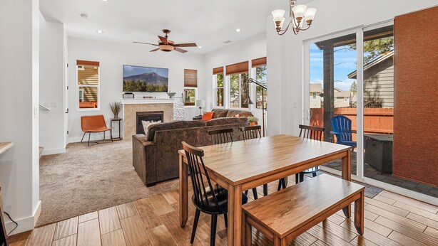 A spacious living area with a fireplace, a large TV, and a dining table with chairs. - Mountain Family Getaway w/AC -Sleeps 8! (Flagstaff)