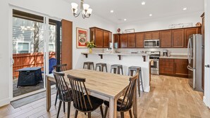 A modern kitchen with wooden cabinets, a central island, and stainless steel appliances. - Mountain Family Getaway w/AC -Sleeps 8! (Flagstaff)