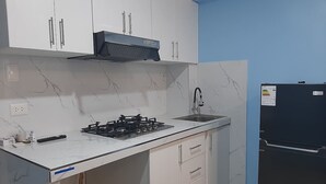 A kitchen with white cabinets, a black refrigerator, a gas stove, and a sink. - Super cozy apartment / apartment close to the airport (Callao)