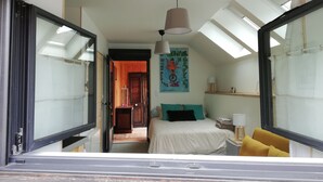 A bedroom with a bed, bedside tables, a hanging lamp, a poster on the wall, and a skylight. - Studio Terre & Mer à Dragey (Dragey)