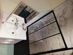Regadera, secadora de cabello, toallas, papel de baño 