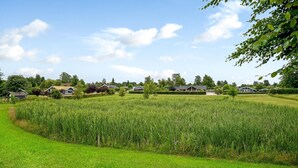 A rural landscape with a field of crops, several houses, and a clear sky. - 2 bedroom amazing home in Skibby (Skibby)