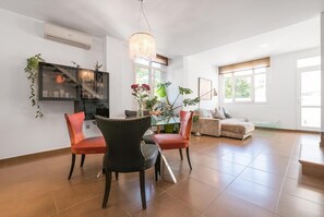 A spacious living room with a dining area, large windows, and a modern chandelier. - Stunning home in Conil de la frontera (Conil de la frontera)