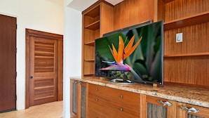 Ein Holzkabinent mit einem Flachbildfernseher darauf, einer Tür und einem gefliesten Boden.
