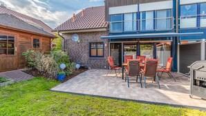 Eine Terrasse mit Sitzgelegenheit und Grill.