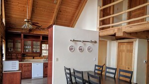 A spacious kitchen with wooden cabinets, a refrigerator, and a dining area with a table and chairs. - Spacious cabin in gated community. (Fort Garland)