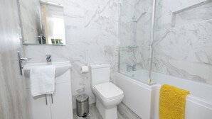 Une salle de bain moderne équipée de toilettes, d’un lavabo et d’une douche.