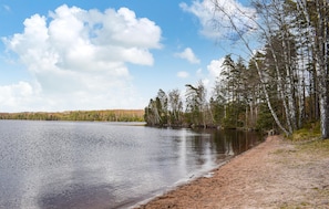 A lake with a sandy shore, surrounded by trees and a clear sky. - 2 bedroom cozy home in Hyltebruk (Hyltebruk)