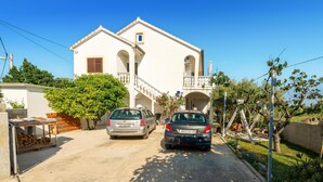 A two-story building with a balcony and a small window. - Amazing apartment in Privlaka with WiFi (Privlaka)