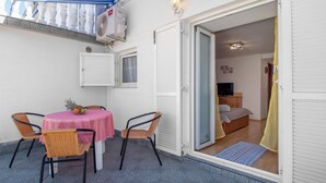 A room with a bed, a television, and a small table with fruit. - Amazing apartment in Jadranovo with WiFi (Jadranovo)