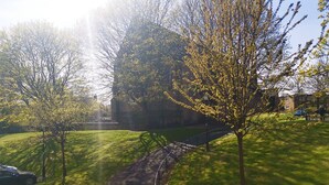 A pathway leading through a grassy area with trees and a building in the background. - Moorish Castle (Newcastle-upon-Tyne)