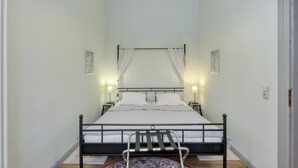 A bedroom with a bed, two bedside tables, a nightstand, a canopy bed, a ceiling light, and two wall-mounted lamps. - 1 bedroom awesome apartment in Krakow am See (Krakow am See)