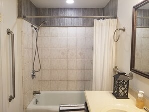 Een bad/douchecombinatie, een haardroger, handdoeken, zeep