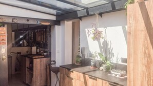 Cozinha com armários de madeira, bancada e planta pendente.