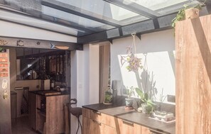 Eine Küche mit Holzausstattung, einer Arbeitsfläche und einer hängenden Pflanze.