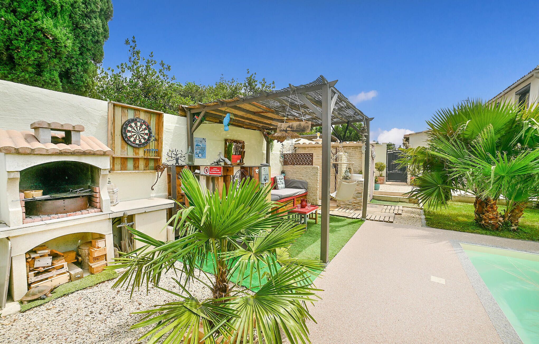 A courtyard with a brick oven, a dartboard, and a hammock.