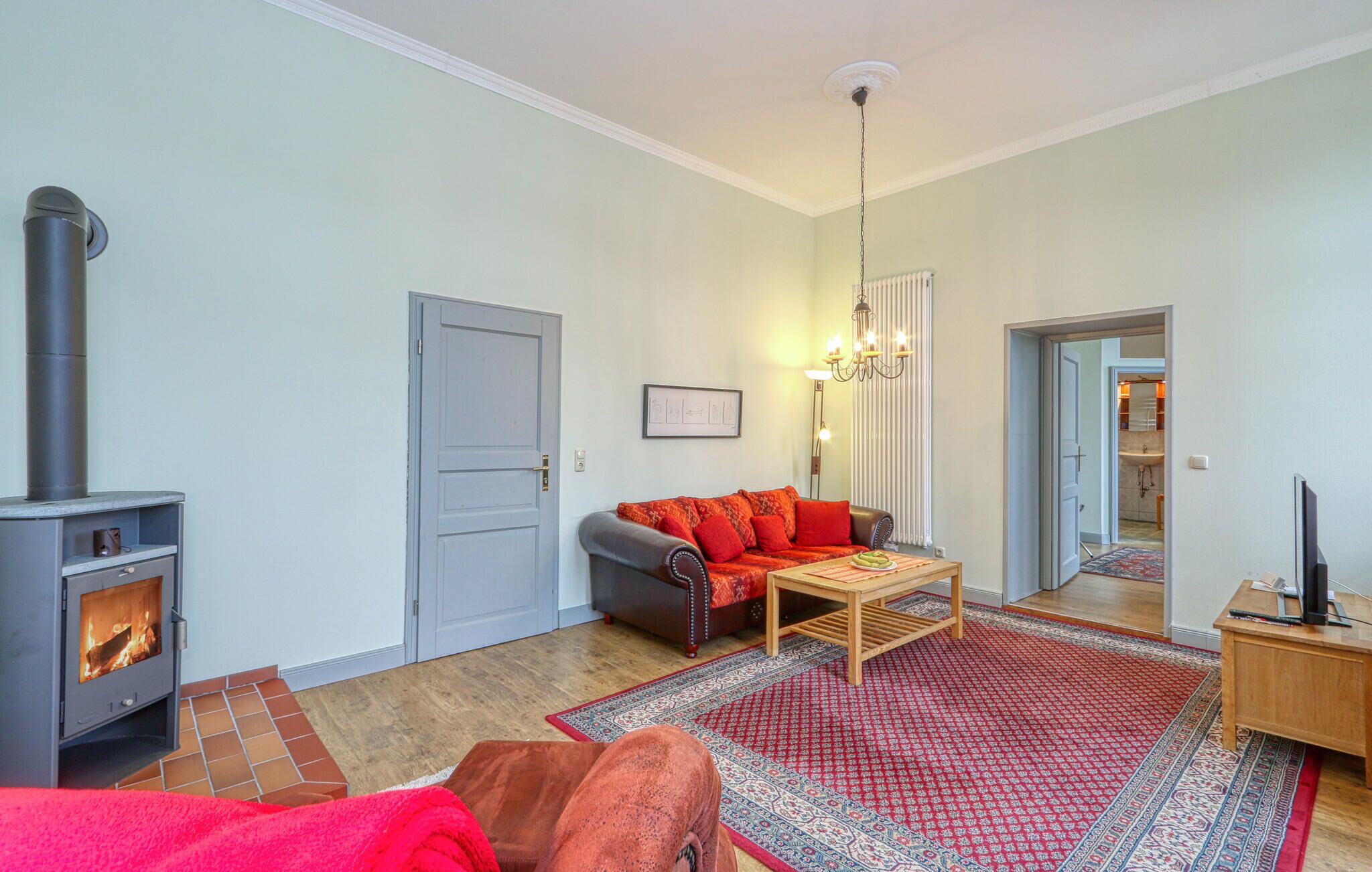 Ein Wohnzimmer mit Kamin, einer Couch, einem Couchtisch und einem Teppich.
