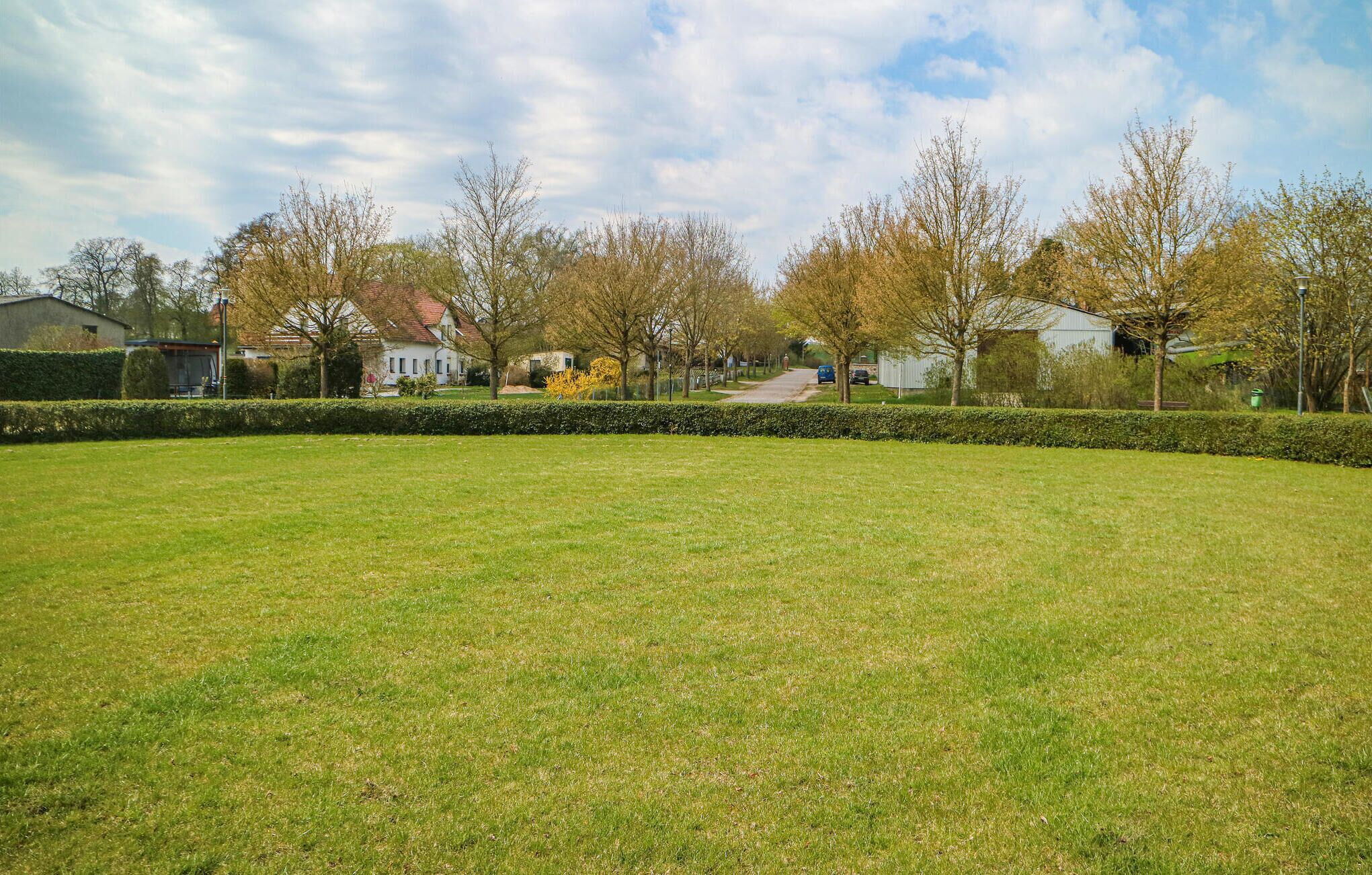 Un parque con césped y un sendero que lleva a una hilera de casas.