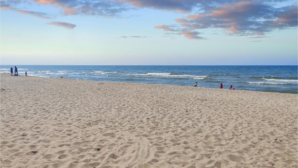 A wide sandy beach with gentle waves and a clear sky. - Pet friendly home in Rewal with WiFi (Rewal)