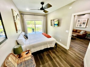 A bedroom with a bed, a ceiling fan, a window, and a door leading to a living area. - *Dream Gruene Getaway* Walk to Gruene! On River! (New Braunfels)