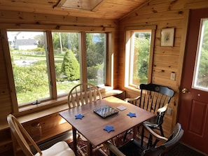 Una cabaña de madera con una mesa de comedor, sillas y un tablero de ajedrez.