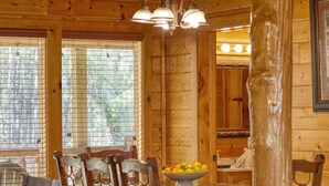 Un interior de madera con una mesa de comedor, sillas y un cuenco de fruta.