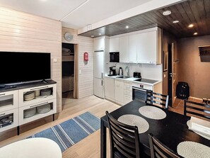 A compact living space with a kitchenette, a dining area, and a television.