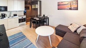 A modern apartment with a kitchen, dining area, and living room.