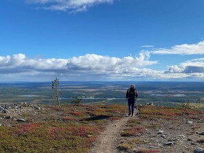 A person hiking on a rocky path with a vast landscape in the background.