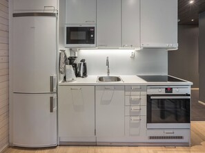 A modern kitchen with a built-in microwave, oven, and sink.