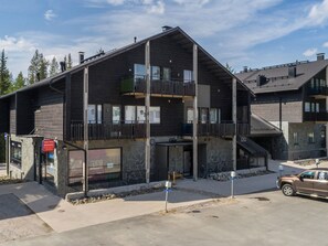 A multi-story building with balconies, a stone facade, and a visible entrance. - Levin stara c12 by Interhome (Kittilä)