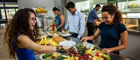 A buffet setup with various food items and a salad.