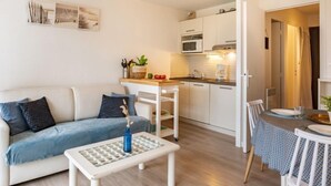 Un salon moderne comprenant un canapé, une table basse et un coin repas avec une table et des chaises.