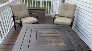 Una terraza con dos sillas y una mesa.