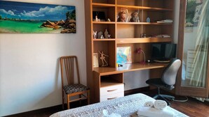 A bedroom with a bed, a wooden desk, a chair, a television, and a bookshelf. - 3 bedrooms villa  Sleeps 6 with Garden (Roma)